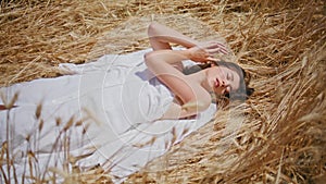 Relaxed model chilling sunny hay land. Meditative woman laying sun field nature