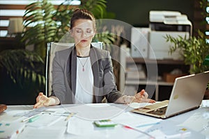 relaxed modern business woman at work with laptop meditating