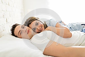 Relaxed Multiethnic Lovers Embracing On Bed