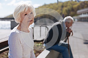 Relaxed old woman expressing sadness in the open air