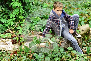 Relaxed and peaceful. Little boy relax sitting on tree. Little boy relax in woods. Relax, life is beautiful