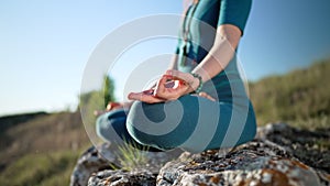 Relaxed peaceful yogi woman sitting in lotus while meditating, feeling free in front of wild nature. Mindful fitness