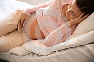 Relaxed pregnant woman on bed in hospital ward during antenatal examination