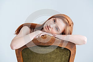 Relaxed redhead woman sitting on the chair