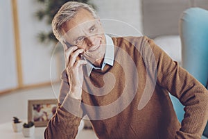 Relaxed senior male person talking per telephone