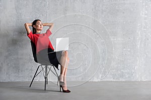 Relaxed smiling girl locating on seat with device