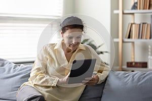 Relaxed smiling mature retired woman using tablet.