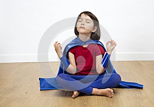 Relaxed superhero child meditating with yoga, mindfulness, meditation, bare feet