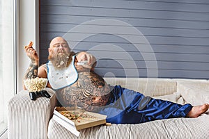 Relaxed thick guy entertaining with pizza and television