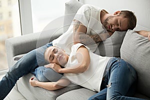 Relaxed tired couple sleeping having nap on comfortable sofa tog