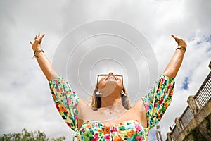 Relaxed woman, arms rised, enjoying sun, freedom and life an a beautiful beach. Young lady feeling free, relaxed and happy.