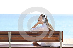 Relaxed woman on a bench listening to music