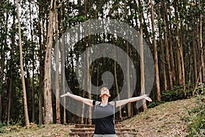 Relaxed woman breathing over beautiful eucalyptus forest landscape. Nature, hiking and sustainability concept