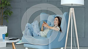 Relaxed woman browsing social media on smart phone