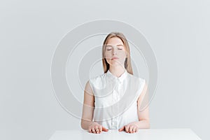 Relaxed woman with closed eyes sitting at the table