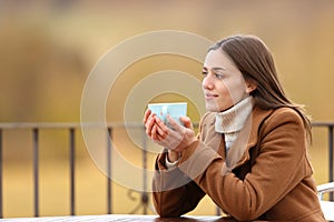 Relaxed woman contemplating drinking in a terrace