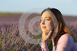 Relaxed woman contemplating a lavender field at sunset