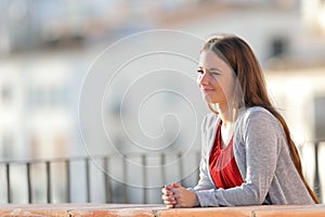Relaxed woman contemplating views from a balcony