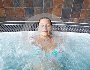 A relaxed woman doing hydromassage in a beauty spa