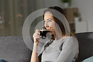 Relaxed woman drinking decaffeinated coffee in the night photo