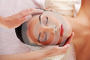 Relaxed woman enjoy receiving face massage at spa