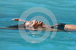 Relaxed woman floating in swimming pool