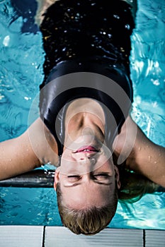 Relaxed woman floating in the swimming pool