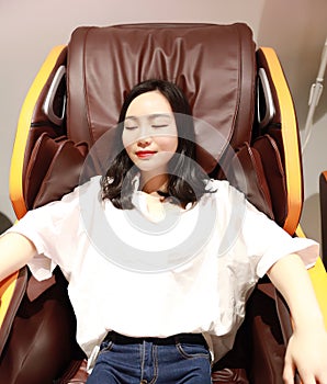 Relaxed woman girl lying on Electric automatic massage chair, enjoy her free comfortable time