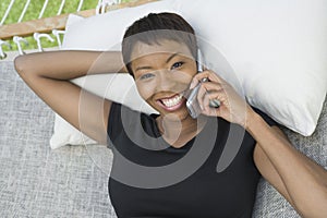 Relaxed Woman On Hammock Using Cell Phone