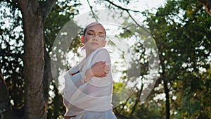 Relaxed woman hugging herself at nature sunlight. Dreamy girl enjoying sunshine