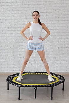 Relaxed woman jumping on trampoline.