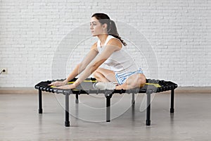 Relaxed woman jumping on trampoline.