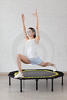 Relaxed woman jumping on trampoline.