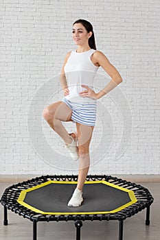 Relaxed woman jumping on trampoline.