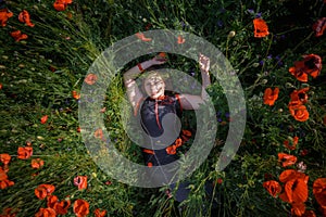 Relaxed woman lies on poppy field