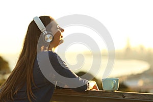 Relaxed woman listening to music breathing at sunset