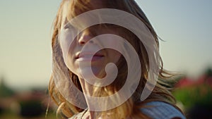 Relaxed woman looking at camera with passion outside. Closeup young female face.