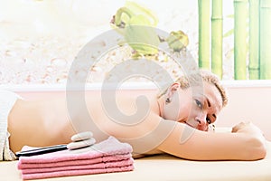 Relaxed woman on massage table receiving beauty treatment at day spa