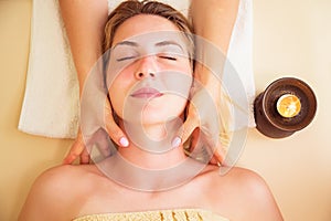 Relaxed woman on massage table receiving beauty treatment at day spa