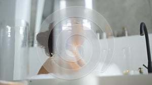 Relaxed woman massaging neck in bathtub. Close up sensual girl relaxing in bath.