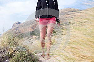Relaxed woman in pink shorts and black hoodie enjoying beautiful nature at serene landscape at Balos beach, Greece