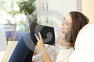 Relaxed woman reading an ebook photo