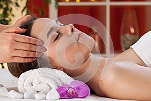 Relaxed woman receiving head massage