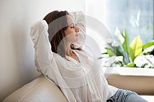 Relaxed woman resting breathing fresh air at home on sofa