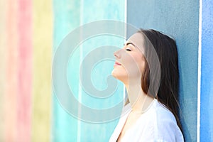 Relaxed woman resting leaning on a colorful wall