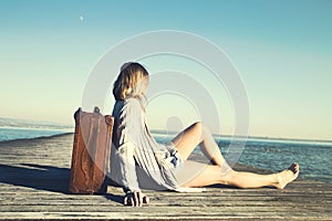 Relaxed woman resting after a long journey with her big suitcase