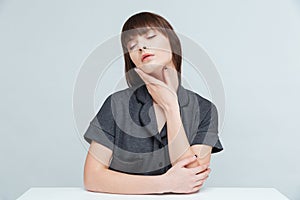 Relaxed woman sitting at the table with closed eyes