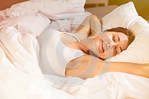 Relaxed woman sleeping in bed