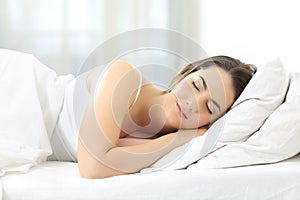 Relaxed woman sleeping on a bed at home photo