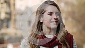 Relaxed woman smiling outdoors. Beautiful hipster girl relaxing on city street.